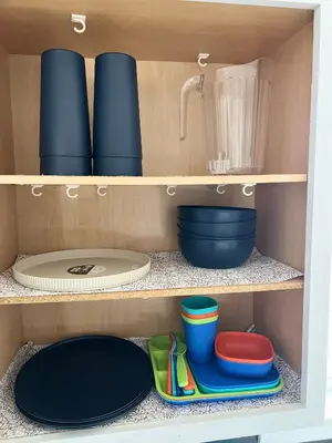 a cupboard with plates and bowls and utensils at Newly renovated home, firepit, game room, grill in Tobyhanna