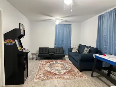 a living room with a couch and a table at Newly renovated home, firepit, game room, grill in Tobyhanna