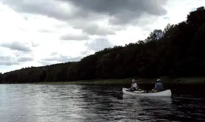 two people sitting in a canoe on a river at Rustic Cabin Retreat on the Ten Mile River in Narrowsburg, New York in Narrowsburg