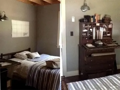 a bedroom with two beds and a dresser with a desk at Charming Cottage Rental with Antique Decor in Narrowsburg, New York in Narrowsburg