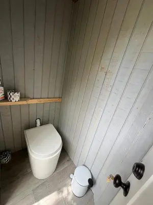 a small bathroom with a toilet in the corner at Eco-Friendly, Abstract Treehouse Surrounded by Wildlife and Hiking Trails For a Special Getaway in Sparrow Bush, New York in Sparrow Bush