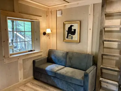 a living room with a couch and a window at Eco-Friendly, Abstract Treehouse Surrounded by Wildlife and Hiking Trails For a Special Getaway in Sparrow Bush, New York in Sparrow Bush