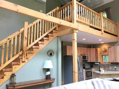 a wooden staircase in a room with a kitchen at Cozy Vacation Rental for 10 with a Fire Pit in Jim Thorpe, Pennsylvania in Jim Thorpe