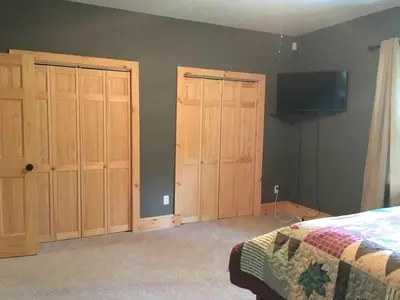 a bedroom with wooden cabinets and a tv on the wall at Cozy Vacation Rental for 10 with a Fire Pit in Jim Thorpe, Pennsylvania in Jim Thorpe