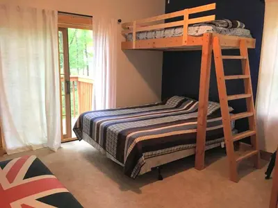 a bedroom with a bunk bed with a ladder at Cozy Vacation Rental for 10 with a Fire Pit in Jim Thorpe, Pennsylvania in Jim Thorpe