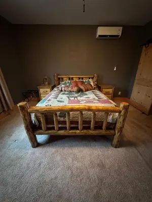 a wooden bed in a room with at Cozy Vacation Rental for 10 with a Fire Pit in Jim Thorpe, Pennsylvania in Jim Thorpe