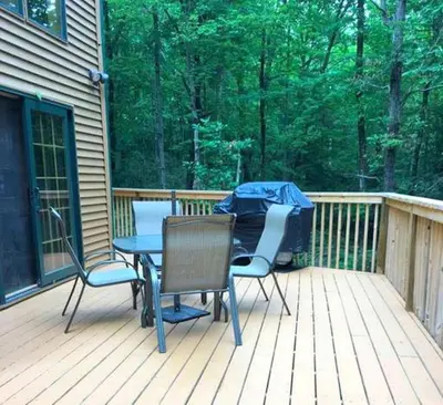 a patio with two chairs and a table on a deck at Cozy Vacation Rental for 10 with a Fire Pit in Jim Thorpe, Pennsylvania in Jim Thorpe