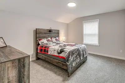 a bedroom with a bed with a wooden headboard at Lake and Pool Access Poconos Family Getaway! in Albrightsville
