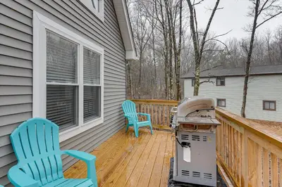 two chairs and a stove on the porch of a house at Lake and Pool Access Poconos Family Getaway! in Albrightsville