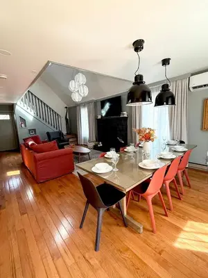 a living room with a dining table and a red couch at Pocono Chalet,Hot Tub,Arcade,Fireplace, Lake,Pool, Pet friendly, near Jim Thorpe No extra fees to use amenities in Towamensing Trails