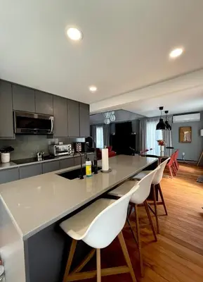a kitchen with a large counter with white chairs at Pocono Chalet,Hot Tub,Arcade,Fireplace, Lake,Pool, Pet friendly, near Jim Thorpe No extra fees to use amenities in Towamensing Trails