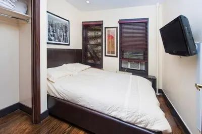 a bedroom with a bed and a flat screen tv at The Ideal II Vibe 8558 in New York