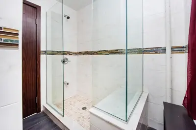 a shower with a glass enclosure in a bathroom at The Ideal II Vibe 8558 in New York