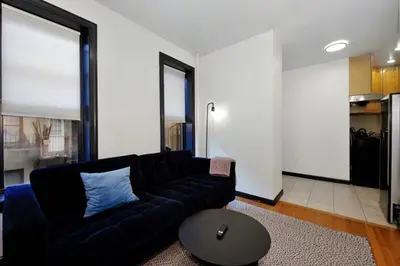 a living room with a black couch and a table at The Gram V Vibe 8615 in New York