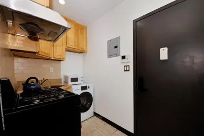 a kitchen with a stove and a black refrigerator at The Gram V Vibe 8615 in New York