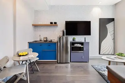 a kitchen with stainless steel appliances and blue cabinets at The Vibe on 5th Vibe 8750 in New York
