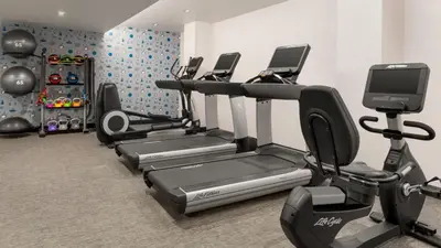 a gym with several cardio machines in a room at The Vibe on 5th IV Vibe 8753 in New York