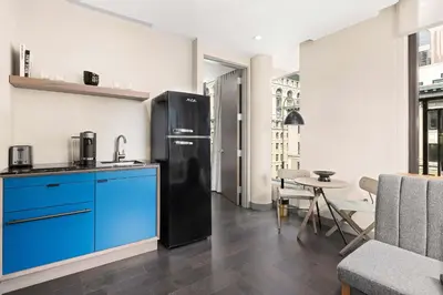 a kitchen with a black refrigerator and a table at The Vibe on 5th XIII Vibe 8762 in New York
