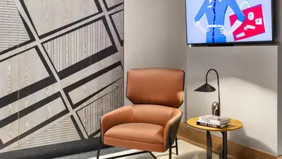 a room with a chair and a tv on a wall at The Vibe on 5th XIII Vibe 8762 in New York