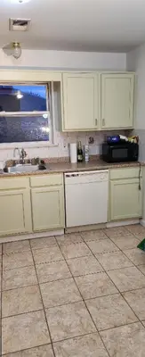 a kitchen with white cabinets and a sink and a window at Gold queen 4A in Newark