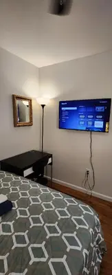 a bedroom with a bed and a flat screen tv on the wall at Gold queen 4A in Newark