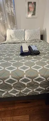 a bed with pillows and a blanket on it at Gold queen 4A in Newark