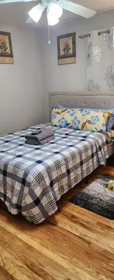 a bedroom with a bed with a plaid blanket at Happiness queen room 3 in Newark