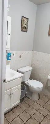 a white bathroom with a toilet and a sink at Happiness queen room 3 in Newark
