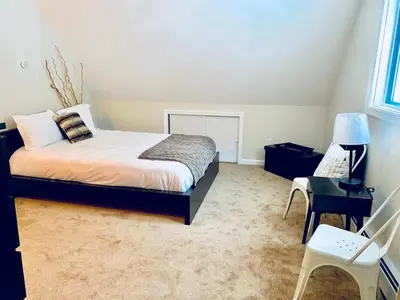 a bedroom with a bed and a desk and a chair at Beautiful Lakefront Chalet in the Poconos! in Hawley
