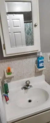a bathroom with a white sink and a mirror at Beautiful Room king in Newark