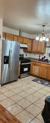 a kitchen with a stainless steel refrigerator and wooden cabinets at Beautiful Room king in Newark