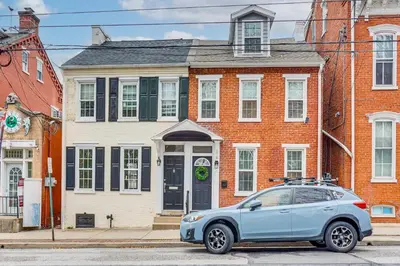 a blue car parked in front of a brick house at Family-Friendly Townhome with Patio in Columbia! in Columbia