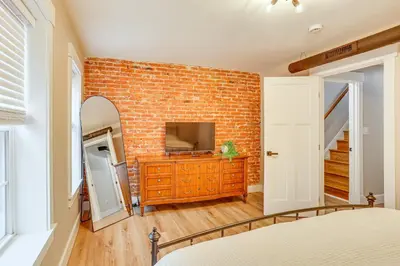 a bedroom with a brick wall and a television on a dresser at Family-Friendly Townhome with Patio in Columbia! in Columbia