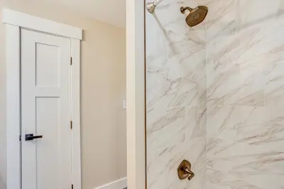a white bathroom with a shower with marble tiles at Family-Friendly Townhome with Patio in Columbia! in Columbia