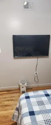 a bedroom with a flat screen tv on the wall at Amazing family house in Newark