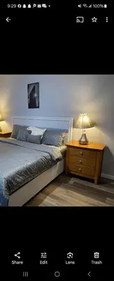 a bedroom with a bed and a table with a lamp at Lemon king room 4 in Newark