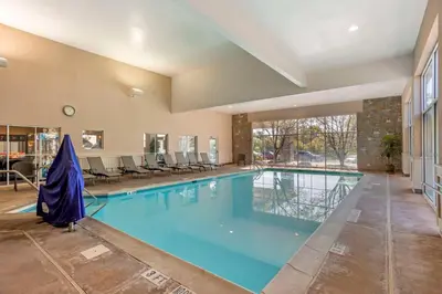 a large swimming pool with blue water in a building at SureStay Studio by Best Western Paradise Lancaster County in Paradise
