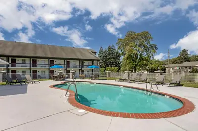 a swimming pool in front of a hotel at SureStay Studio by Best Western Paradise Lancaster County in Paradise