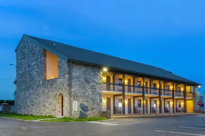 a large stone building with lights on at SureStay Studio by Best Western Paradise Lancaster County in Paradise