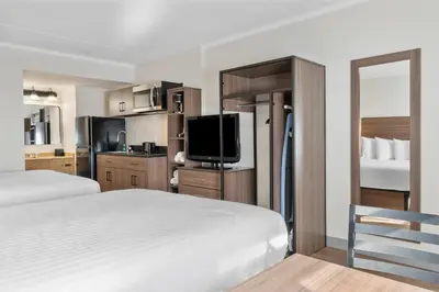 a hotel room with a bed and a flat screen tv at SureStay Studio by Best Western Paradise Lancaster County in Paradise