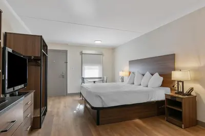 a hotel room with a bed and a flat screen tv at SureStay Studio by Best Western Paradise Lancaster County in Paradise