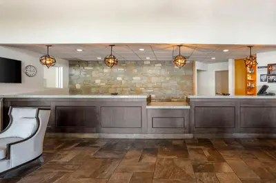 a large lobby with a bar with a stone wall at SureStay Studio by Best Western Paradise Lancaster County in Paradise