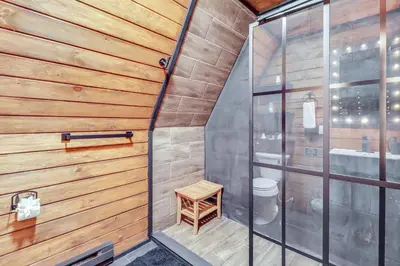 a small bathroom with wooden walls and a toilet at 9 Mi to Big Boulder Mtn A-Frame Cabin with Hot Tub in Albrightsville