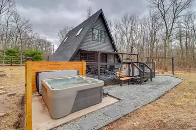a house with a hot tub and a house at 9 Mi to Big Boulder Mtn A-Frame Cabin with Hot Tub in Albrightsville