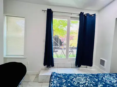 a bedroom with a bed and a window with blue curtains at f and R in Philadelphia