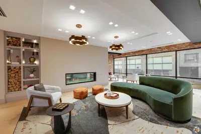 a living room with a green couch and a fireplace at Luxury Apartments by Hyatus Center City in Philadelphia