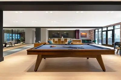a pool table in the middle of a living room at Luxury Apartments by Hyatus Center City in Philadelphia