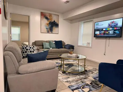 a living room with a couch and a tv at Cosy Bedroom 6 minutes to EWR Prudential Hotels Pen station in Newark