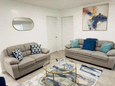 a living room with two couches and a glass table at Cosy Bedroom 6 minutes to EWR Prudential Hotels Pen station in Newark