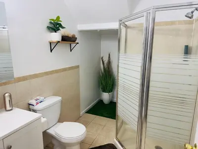 a bathroom with a toilet and a glass shower at Cosy Bedroom 6 minutes to EWR Prudential Hotels Pen station in Newark
